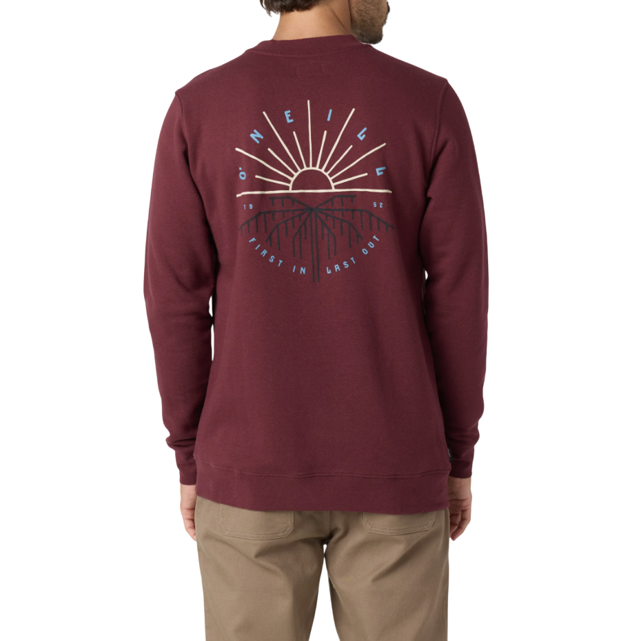 A burgundy O'Neill sweatshirt featuring a graphic on the back with a sun and mountain design, along with the text \“First In Last Out\“ and \“1952\“. Paired with beige pants.