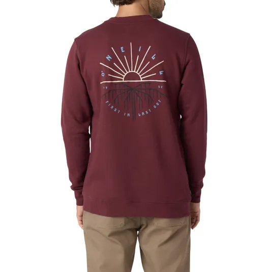 A burgundy O'Neill sweatshirt featuring a graphic on the back with a sun and mountain design, along with the text \“First In Last Out\“ and \“1952\“. Paired with beige pants.