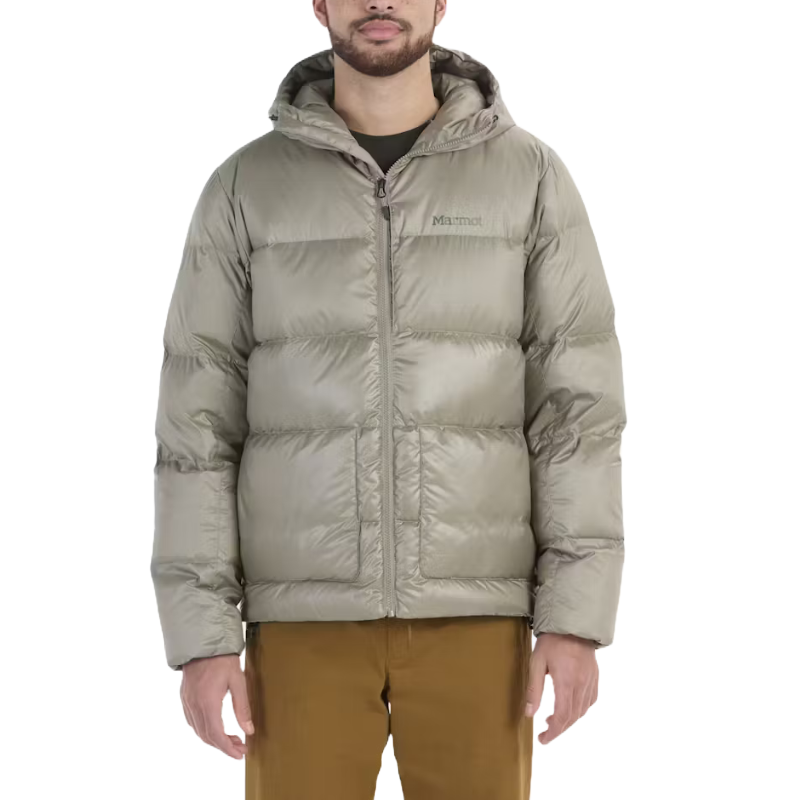 A person is wearing a light gray Marmot puffer jacket with a hood, paired with brown pants.