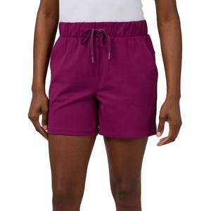 A person is wearing purple athletic shorts with an elastic waistband and a drawstring, paired with a white top.