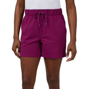 A person is wearing purple athletic shorts with an elastic waistband and a drawstring, paired with a white top.
