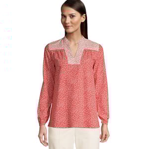 Red and white floral print peasant shirt with a V-neckline and contrasting patterned yoke, featuring long sleeves and a relaxed fit, paired with white pants.
