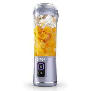 Ninja Blast Portable Blender is a compact, travel-friendly blender equipped with a blending jar filled with ice and fruit. It features a start/stop button and a power button on its base, designed for on-the-go blending.