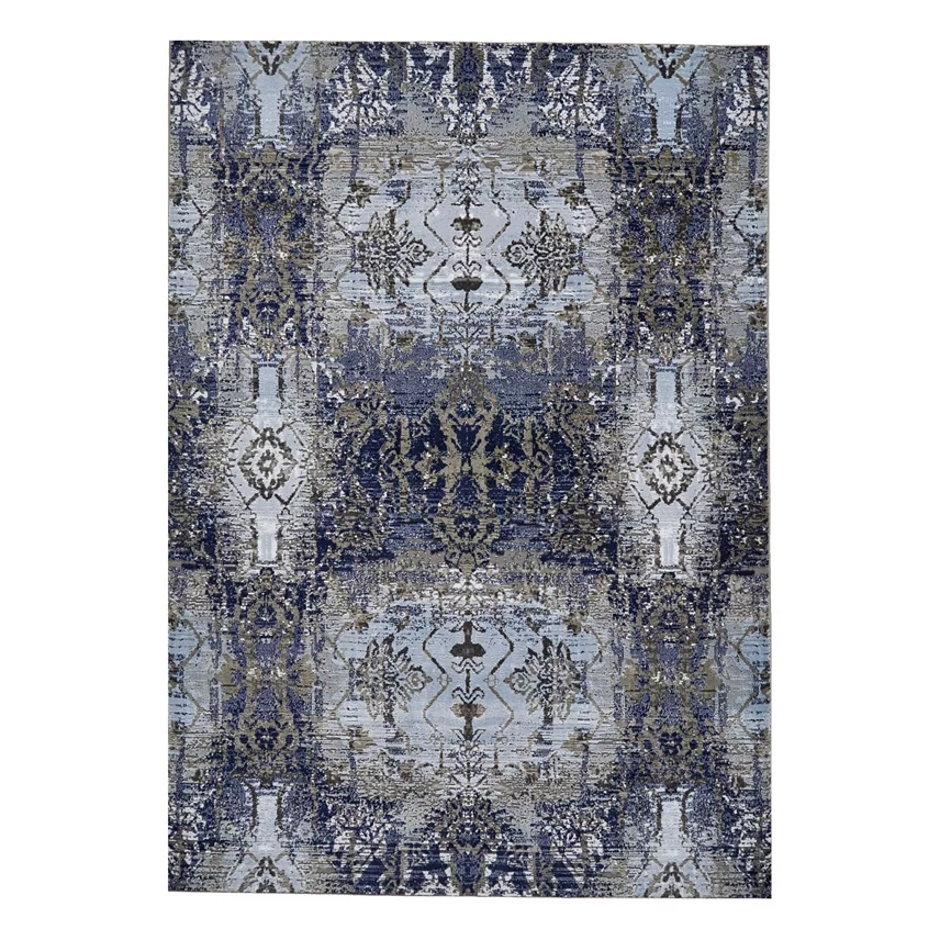 A 5'2\“ x 7'2\“ area rug featuring a symmetrical pattern with floral and geometric designs in shades of blue and grey.