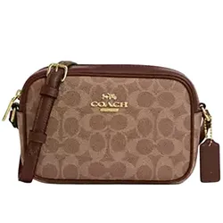 A brown Coach crossbody bag features the signature monogram pattern, gold-toned hardware, and an adjustable strap with a leather tag.