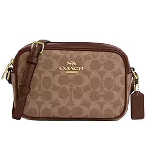A brown Coach crossbody bag features the signature monogram pattern, gold-toned hardware, and an adjustable strap with a leather tag.