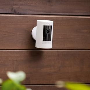 A security camera is mounted on a wooden wall, highlighting its versatile mounting options.