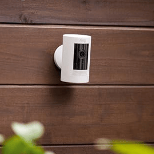 A security camera is mounted on a wooden wall, highlighting its versatile mounting options.