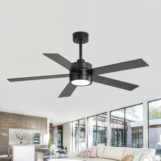A modern black ceiling fan with five blades and integrated light fixture is installed in a spacious, contemporary living room with large windows, a white sofa, and a minimalist décor.