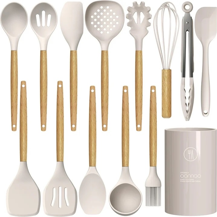 A set of kitchen utensils with wooden handles, including spatulas, spoons, a pasta server, tongs, a whisk, a can opener, and a brush, plus a storage caddy.