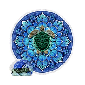 A 60\“ round beach towel features a vibrant blue mandala pattern with a detailed green sea turtle in the center. The towel's edges are fringed, and it is shown rolled, highlighting its matching design.