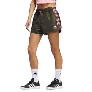Adidas Sunglass Woven Shorts are olive green with pink side stripes, featuring an elastic waistband, pink drawstring, and a small logo on the left leg. They're paired with black Adidas sneakers, white socks, and a pink crop top.