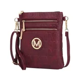 Maroon crossbody bag with embossed \“M\“ pattern, featuring a gold circular logo with an \“M\“ and rhinestones, two front zip pockets, and a detachable strap.