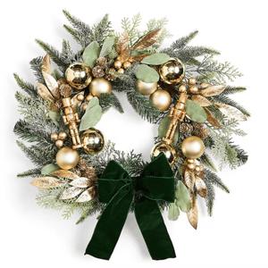 A decorative wreath featuring green and gold elements, including glossy spheres, leafy accents, small nutcracker figures, and a velvet green ribbon.