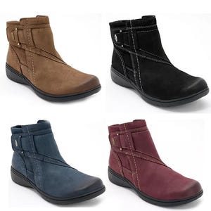 Four pairs of ankle boots in different colors: tan, black, blue, and burgundy, all with side zippers.