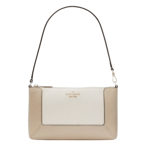 A two-tone beige and cream leather shoulder bag with a short strap, featuring the Kate Spade New York logo on the front.