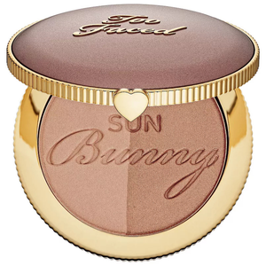 Too Faced Sun Bunny Natural Bronzer is a dual-shade bronzer in a round, gold-toned compact with the brand's logo on top and a heart detail. The bronzer features a shimmer finish for a sun-kissed glow.
