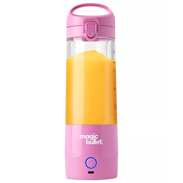 A pink Magic Bullet portable blender filled with orange liquid, featuring a handle, secure top, and power button.