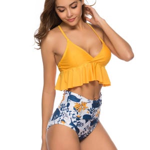 Yellow ruffle top bikini with spaghetti straps paired with high-waisted floral print bottoms in white, blue, and yellow.