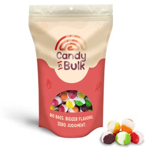 1lb Freeze-Dried Skittles in a resealable pouch labeled \“Candy in Bulk\“ with the tagline \“Big Bags. Bigger Flavors. Zero Judgment.\“ The packaging has a clear window showing colorful candies, and a small pile of Skittles is displayed outside the bag.