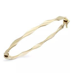 A sleek 10k gold twist bangle bracelet featuring a wavy design, equipped with a hinged closure for secure wear.