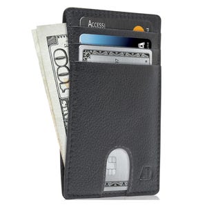 A black slim wallet holding cash and multiple credit cards.