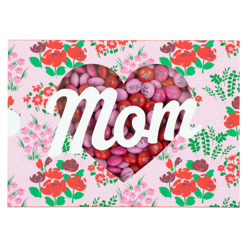 Mother's Day Gift Box featuring M&M's in red and pink colors, with \“Mom\“ in white script and surrounded by a floral pattern. The heart-shaped window displays the colorful candies.