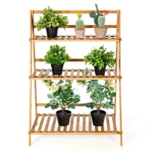 A wooden plant shelf with three tiers holds potted plants, including a variety of green leafy plants and a cactus. Each shelf features slatted design for drainage and airflow.