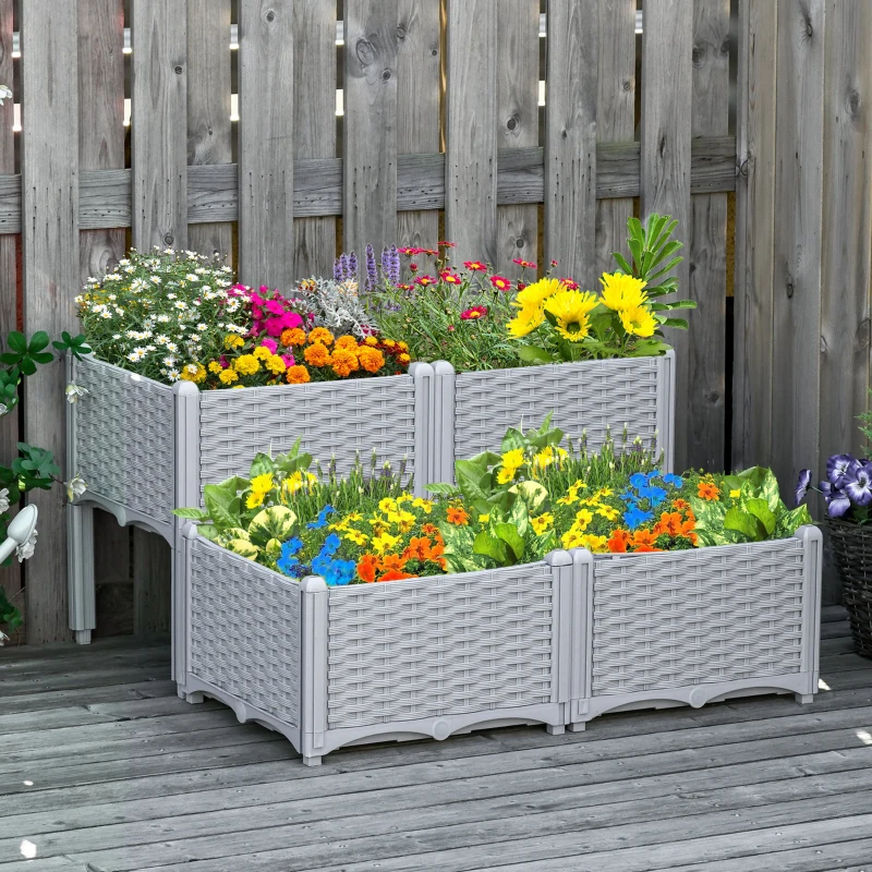 A tiered garden planter with a wicker-style design, featuring a variety of colorful flowers arranged in three sections. Placed on a wooden deck against a wooden fence.