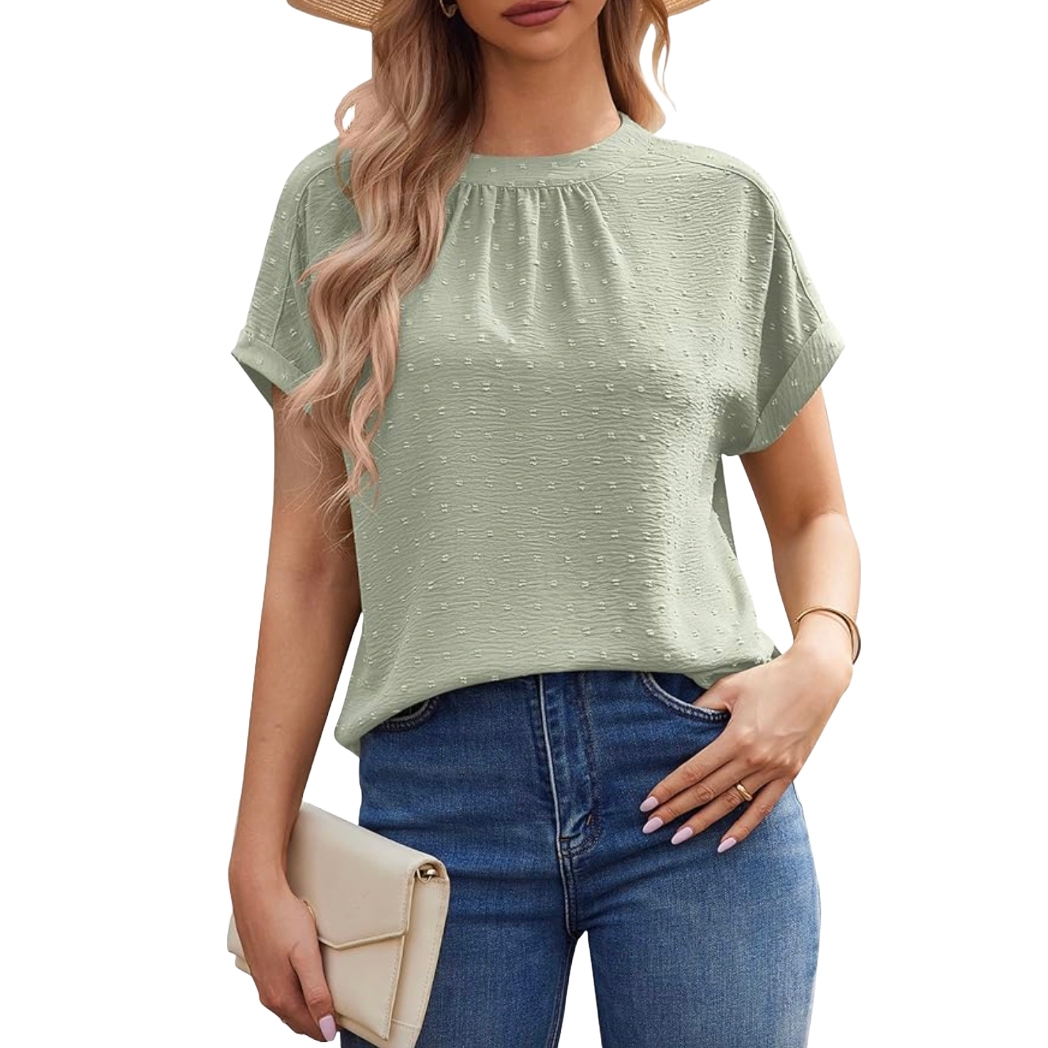 A woman is wearing a light green textured short-sleeve blouse paired with blue jeans, a straw hat, a cream clutch, and minimal jewelry.