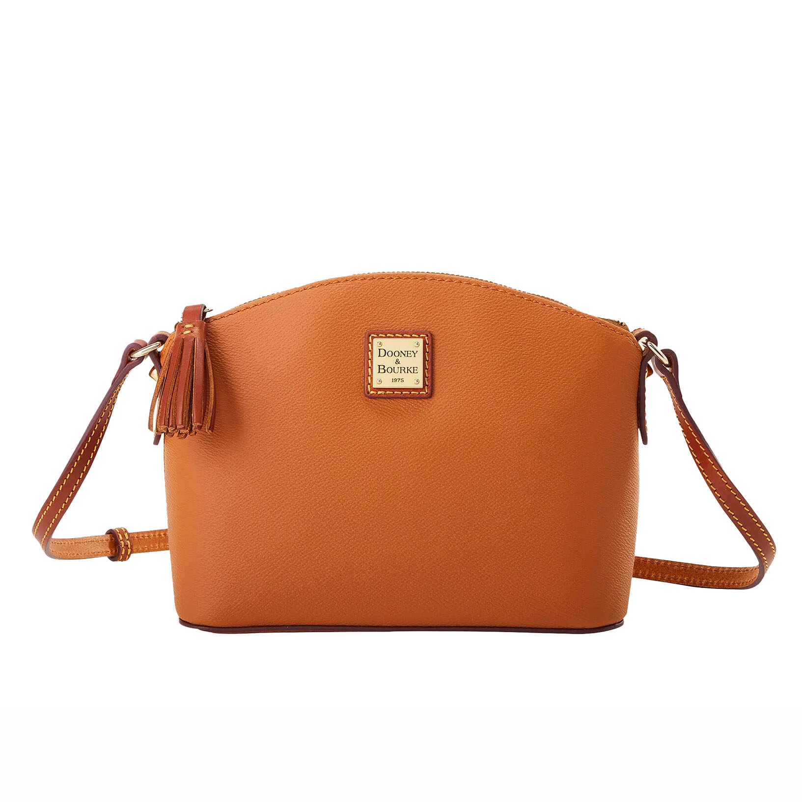 Dooney & Bourke Leather Crossbody in a light brown hue with a curved top, featuring a tassel detail, gold-tone logo plate, and an adjustable crossbody strap.