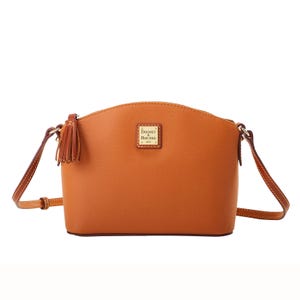 Dooney & Bourke Leather Crossbody in a light brown hue with a curved top, featuring a tassel detail, gold-tone logo plate, and an adjustable crossbody strap.