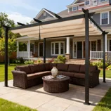 A patio features a wicker sectional sofa with brown cushions, a round wicker coffee table, and a pergola with a retractable canopy.