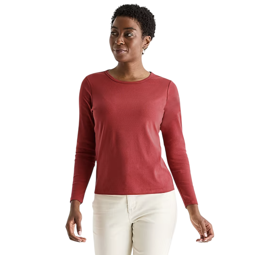A woman models a long-sleeve, dark red top paired with off-white pants against a plain background.