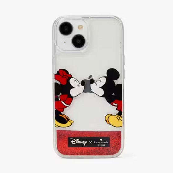 A clear iPhone case featuring Mickey and Minnie Mouse kissing, with a red glitter section at the bottom and the Disney X Kate Spade branding.