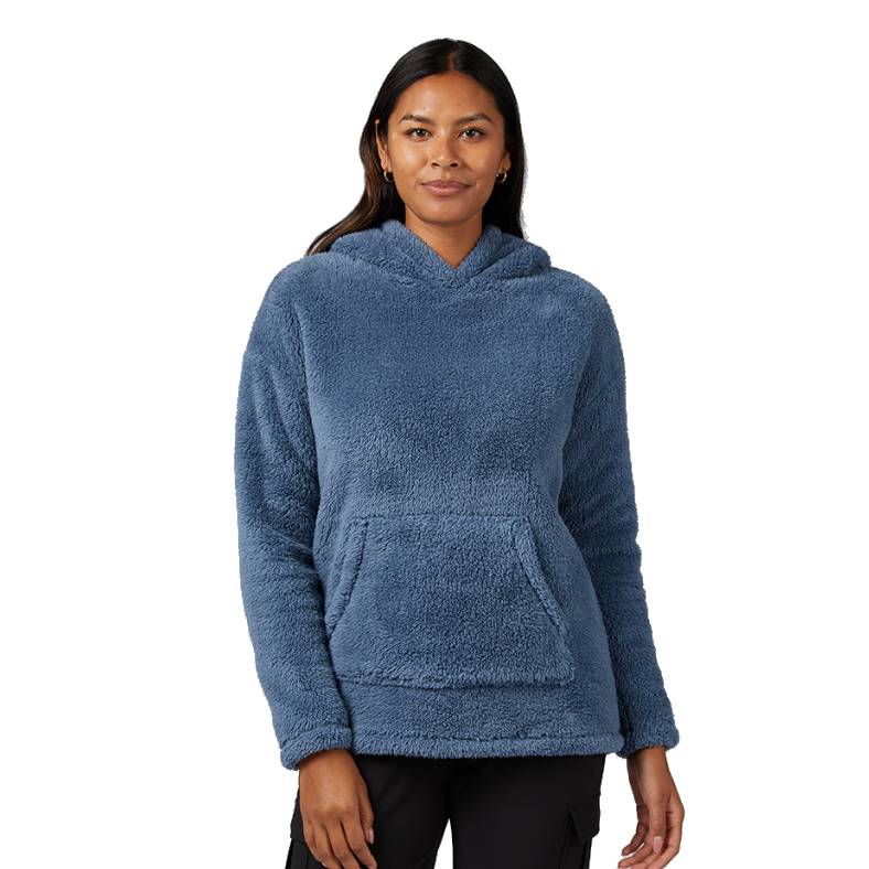A person wearing a blue, plush fleece pullover hoodie with a front pocket, paired with black pants.