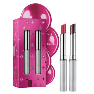Two silver lipsticks are shown alongside a vibrant pink gift box featuring star designs and space for \“To/From\“ labeling.