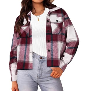 A women's cropped shacket featuring a burgundy, black, and white plaid pattern. It has a button-up front, chest pocket, and is paired with a white ribbed top and light blue jeans.
