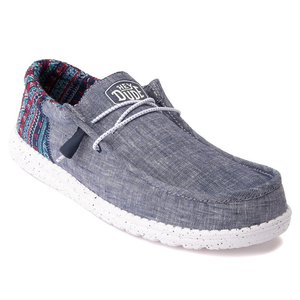 A casual, slip-on shoe with a denim-style fabric upper and a white, splotched sole.
