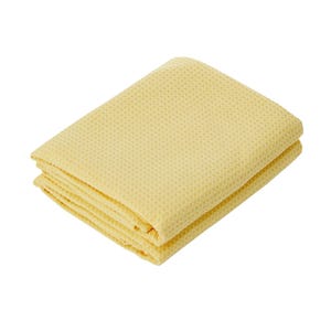 A folded yellow waffle-weave towel against a white background.