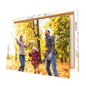 Canvas print of a family enjoying autumn leaves, with barcode and size labels on the frame.