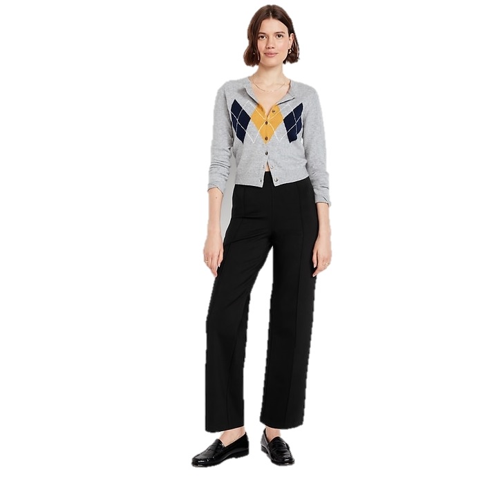 A woman is wearing a gray argyle cardigan with yellow and blue accents, paired with black straight-leg pants and black loafers.