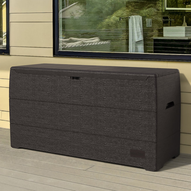 A large, dark woven outdoor storage box with a flat lid and side handles.