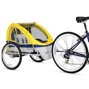 Schwinn 2-Seat Bike Trailer with a yellow and gray canopy, mesh windows, and two harnessed seats, attaches to the rear wheel of a bicycle for easy transport of children.