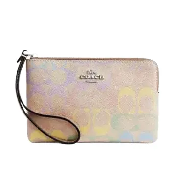 A Coach wristlet with a colorful abstract design, featuring a black strap and the Coach logo in the center.