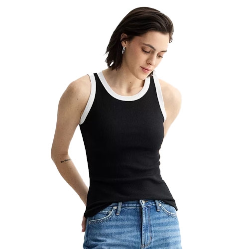 A person is wearing a black ribbed tank top with white trim paired with blue jeans.