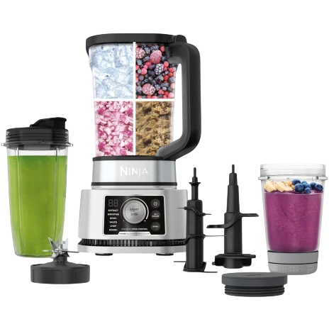 Ninja kitchen system with a blender, interchangeable blades, and attachable cups for smoothies. Includes ingredients like ice, berries, and seeds, showcasing versatility.