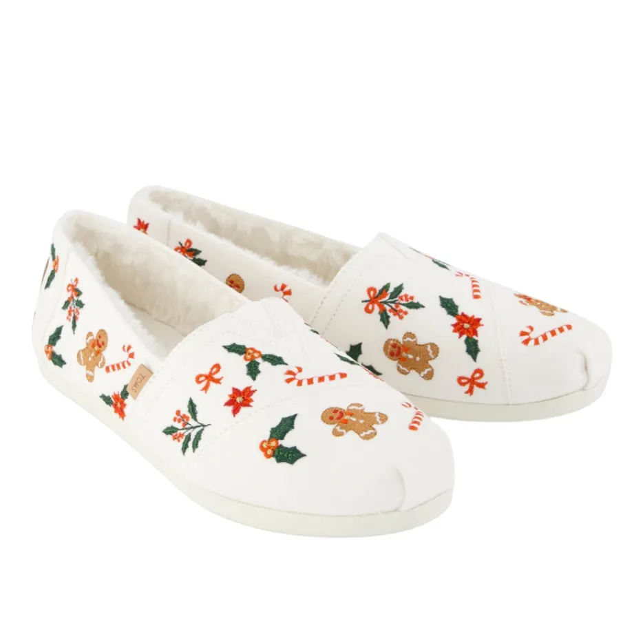 White slip-on shoes with festive embroidery featuring gingerbread men, holly, candy canes, and poinsettias; lined with faux fur.