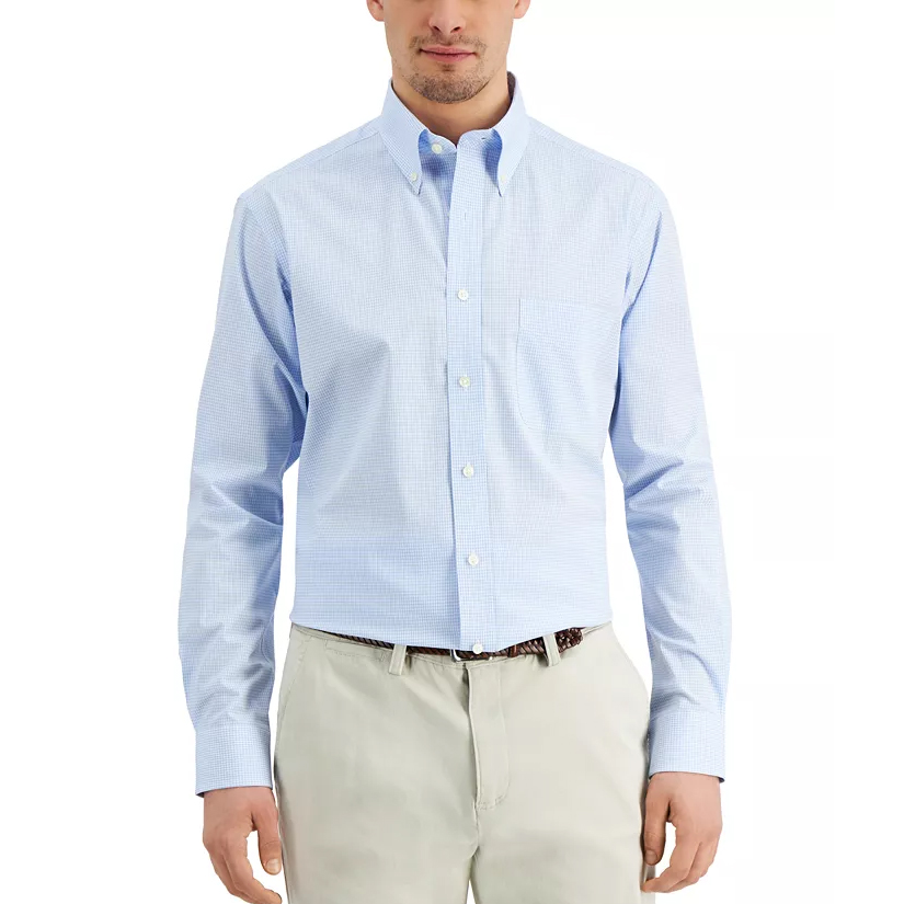 A man wears a light blue button-up shirt with a subtle check pattern and khaki pants.