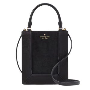 A black Kate Spade mini tote with a suede texture, featuring top handles, a gold-tone logo on the front, and a detachable shoulder strap.